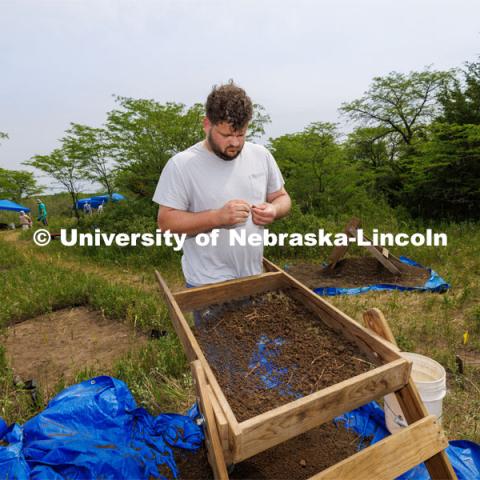 Dalton Carder, a senior in anthropology, looks at a piece sifted from his dig area. LuAnn Wandsnider is leading anthropology and forensic anthropology digs at the Reller Prairie in southwest Lancaster County. June 9, 2023. Photo by Craig Chandler / University Communication.