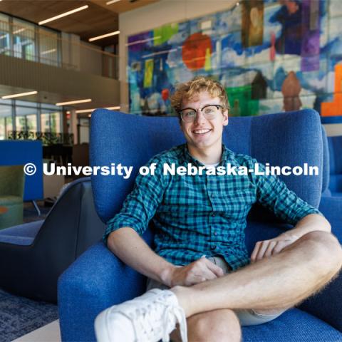 Paul Pechous, ASUN President is photographed sitting in a blue chair in the lobby of Carolyn Pope Edwards Hall. July 26, 2023. Photo by Matthew Strasburger / University Communication.