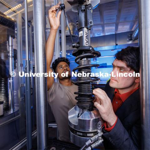 Cody Stolle, right, and Gnyarienn Selva Kumar work on setting up a strut for a compression test while Doreen Rahman does the same for a concrete sample. The two students are masters students in mechanical engineering. they work in Cody Stolle’s lab in Whittier. July 27, 2023.  Photo by Craig Chandler / University Communication.