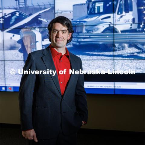 Cody Stolle, Research Assistant Professor, Midwest Roadside Safety Facility, stands in front of a crash video footage from testing done at the UNL Midwest Roadside Safety Facility. Cody Stolle lab in Whittier. July 27, 2023.  Photo by Craig Chandler / University Communication.