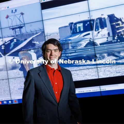 Cody Stolle, Research Assistant Professor, Midwest Roadside Safety Facility, stands in front of a crash video footage from testing done at the UNL Midwest Roadside Safety Facility. Cody Stolle lab in Whittier. July 27, 2023.  Photo by Craig Chandler / University Communication.