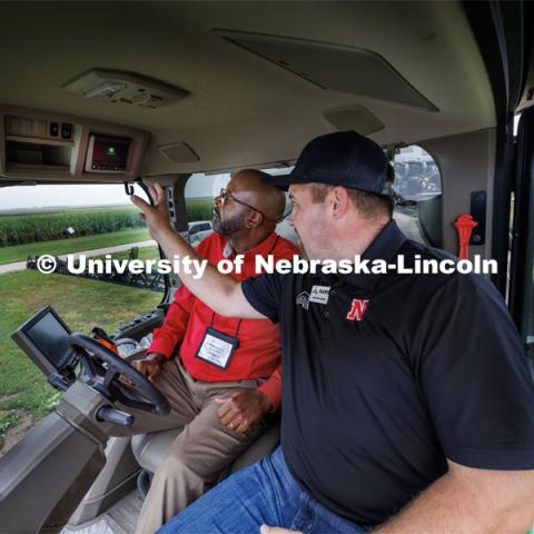 Chancellor Rodney Bennett rides in the cab of a John Deere 612R self-propelled spraying rig as Quentin Cooksley, Director of Commercial and Application Business at AKRS Equipment and UNL alumni, describes the computer system that uses cameras and computers to only spray the weeds. The sprayer was being demonstrated at the South Central Ag Lab field day for area farmers. IANR Roads Scholar Tour through Nebraska. August 1, 2023. Photo by Craig Chandler / University Communication.