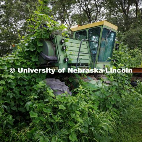 Vines engulf an old John Deere combine. Filming of the movie using UNL students as the production crew. Richard Endacott earned multiple awards for his screenplay, "Turn Over." Story about keeping the family farm operating in the modern era as two brothers come together via restoring an old tractor to help fund their operations. August 9, 2023. Photo by Craig Chandler / University Communication.