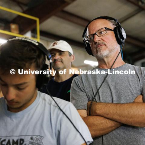 Richard Endacott watches the filming on a remote monitor over the shoulder of UNL student and script supervisor Charlie Major. Filming of the movie using UNL students as the production crew. Endacott earned multiple awards for his screenplay, "Turn Over." Story about keeping the family farm operating in the modern era as two brothers come together via restoring an old tractor to help fund their operations. August 9, 2023. Photo by Craig Chandler / University Communication.