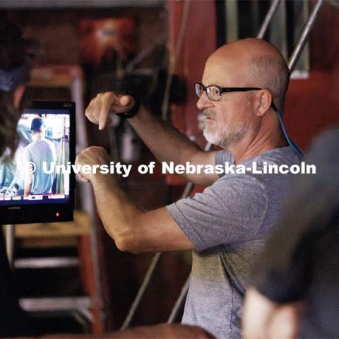 Richard Endacott discusses a scene being replayed on the monitor. Filming of the movie using UNL students as the production crew. Richard Endacott earned multiple awards for his screenplay, "Turn Over." Story about keeping the family farm operating in the modern era as two brothers come together via restoring an old tractor to help fund their operations. August 9, 2023. Photo by Craig Chandler / University Communication.