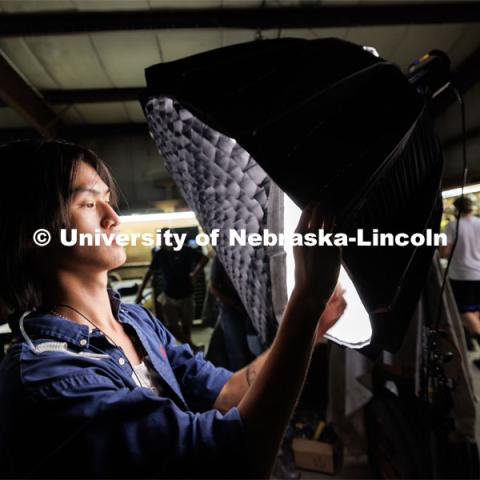 Ethan Ma, a May UNL graduate, adjusts a grid on a light. He is interested in making his career in cinema lighting and is working on the production. Filming of the movie using UNL students as the production crew. Richard Endacott earned multiple awards for his screenplay, "Turn Over." Story about keeping the family farm operating in the modern era as two brothers come together via restoring an old tractor to help fund their operations. August 9, 2023. Photo by Craig Chandler / University Communication.