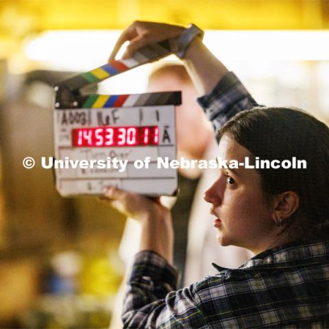 Grace Birkland second assistant cameraperson claps the start of a scene. Filming of the movie using UNL students as the production crew. Richard Endacott earned multiple awards for his screenplay, "Turn Over." Story about keeping the family farm operating in the modern era as two brothers come together via restoring an old tractor to help fund their operations. August 9, 2023. Photo by Craig Chandler / University Communication.