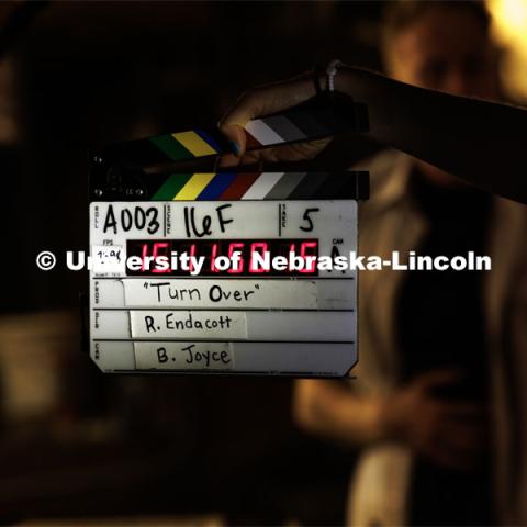 A scene is clapped to begin. Filming of the movie using UNL students as the production crew. Richard Endacott earned multiple awards for his screenplay, "Turn Over." Story about keeping the family farm operating in the modern era as two brothers come together via restoring an old tractor to help fund their operations. August 9, 2023. Photo by Craig Chandler / University Communication.