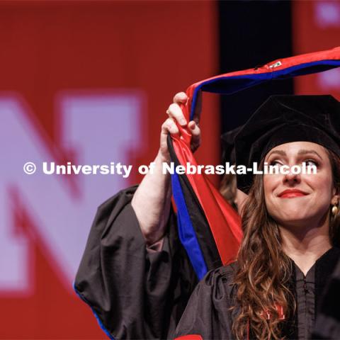 Sonia Lindner watches as her doctoral hood is placed over her head. The University of Nebraska–Lincoln is conferring 588 degrees during the combined graduate and undergraduate commencement ceremony at Pinnacle Bank Arena. August 12, 2023. Photo by Craig Chandler/ University Communication.