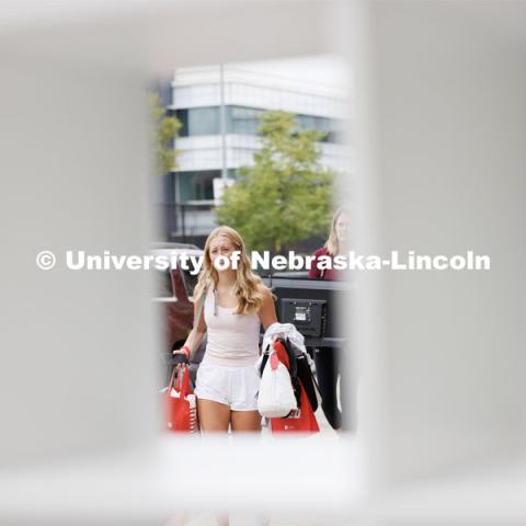 Taylor Steenson of Kansas City, Kansas, carries her belongings into University Suites. Sunday early arrival move-in for sorority rush. August 13, 2023. Photo by Craig Chandler / University Communication.
