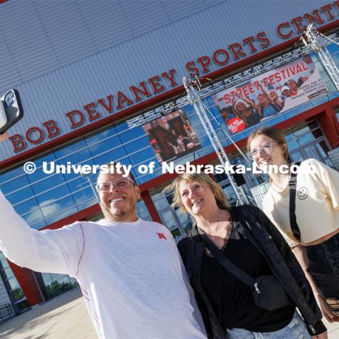 Marissa Brewer of Omaha, right, poses for a selfie with her mom and dad, John and Michelle, as they enter Devaney Sports Center to start the move-in process. First day of residence hall move-in. August 14, 2023. Photo by Craig Chandler/ University Communication.