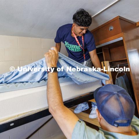 Jose Lopez of Gibbon works on making his bed with help of his dad, Jose, and his sister, Stephanie (in mirror). Jose is majoring in Sports Media in the CoJMC. First day of residence hall move-in. August 14, 2023. Photo by Craig Chandler/ University Communication.