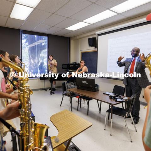 Chancellor Rodney Bennett follows the direction of Drum Major Steffani Nolda, center, and saxophone section leader Cyphers Stewart as Bennett helps lead the saxophone section in the fight song. Cornhusker Marching Band practice. August 17, 2023. Photo by Craig Chandler/ University Communication.