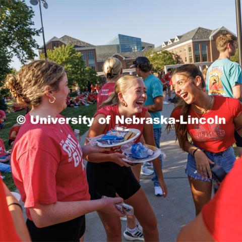 Marcy Smith of Ft. Lauderdale, Florida, center, shares a laugh with Mara Gleeson of St. Paul, Minnesota, and Carmella Chavez of Omaha. Chancellor’s BBQ in the green space between the Nebraska Union and Kauffmann Academic Residence Center. August 18, 2023. Photo by Matthew Strasburger / University Communication.