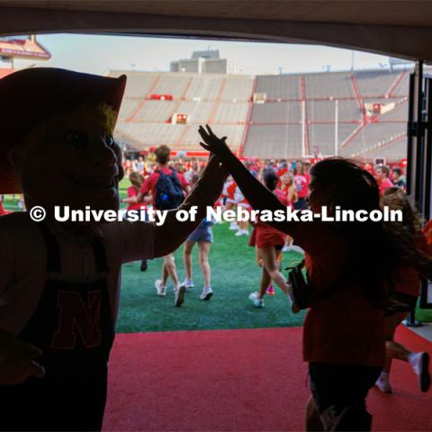 Students high five Herbie Husker as they charge out of the gates at the Tunnel Walk. Tunnel Walk in Memorial Stadium. August 18, 2023. Photo by Craig Chandler / University Communication.