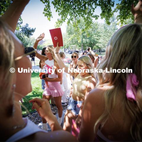 Ella Mandolfo runs through the gauntlet of her new Alpha Xi sorority sisters. Sorority Bid Day in the Cather Dining Complex and on the Vine Street Fields. August 19, 2023. Photo by Craig Chandler / University Communication.