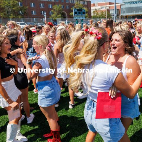 Ava Flood, right, greets her Alpha Phi big sister Izzy Jarecki. Sorority Bid Day in the Cather Dining Complex and on the Vine Street Fields. August 19, 2023. Photo by Craig Chandler / University Communication.