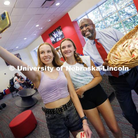 Chancellor Rodney Bennett poses so Sarah Elftmann, a sophomore from Bennington Nebraska, can take a selfie with him and Ashley Anderson, a freshman from Bennington, Nebraska, during the chancellor’s cookie give-away Monday morning. First day of classes for fall semester. August 21, 2023. Photo by Craig Chandler / University Communication.