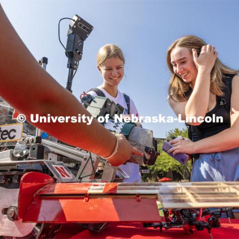 Emily Ciesielski, left, and Jillian Weland, both freshman from Omaha, look over the robotic drilling machine as part of the College of Engineering’s Aerospace Club. Club Fair on city campus. Club Fair is a part of Big Red Welcome. August 29, 2023. Photo by Craig Chandler/ University Communication.