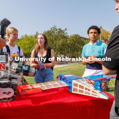 Emily Ciesielski, left, Jillian Weland, and Wilson Overfield all freshman from Omaha, look over the College of Engineering’s Aerospace Club table. Club Fair on city campus. Club Fair is a part of Big Red Welcome. August 29, 2023. Photo by Craig Chandler/ University Communication.