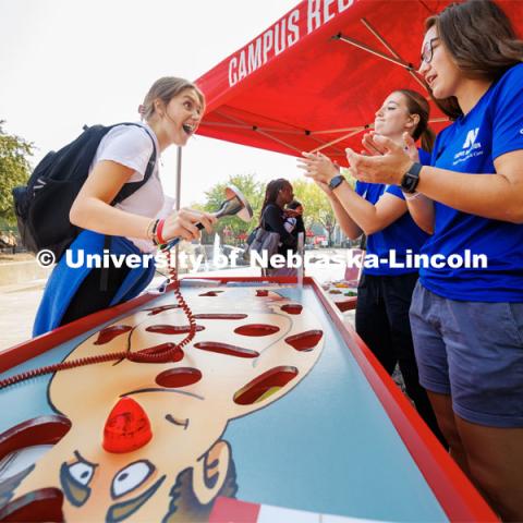 Maddie Wiswell, a freshman from Omaha, is applauded by members of the Campus Rec injury prevention and care team after Wiswell removed a basketball from the patient in an oversized Operation game. Campus Safety Fair in front of Nebraska Union. September 7, 2023. Photo by Craig Chandler / University Communication.