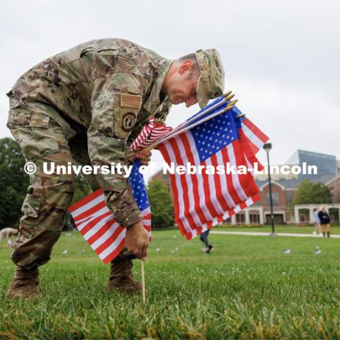 Air Force Lieutenant Colonel Phil Garito plants American flags around a section of the green space north of the Nebraska Union. ASUN, the Military and Veteran Success Center and UNL staff placed flags in the greenspace by the Nebraska Union and on East Campus in remembrance of 9/11. September 11, 2023. Photo by Craig Chandler / University Communication.