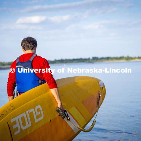 Paddleboarders carry their boards into Branched Oak Lake. About Lincoln - Paddleboarding at Branched Oak Lake with Campus Rec. September 13, 2023. Photo by Kristen Labadie / University Communication.