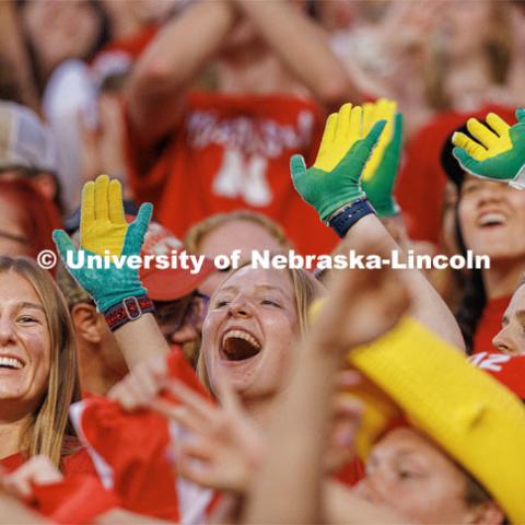 Jada Scribner, left, and Eva Gronewold are among a group in the stands showing off their corn gloves. Northern Illinois football in Memorial Stadium. September 16, 2023. Photo by Craig Chandler / University Communication.