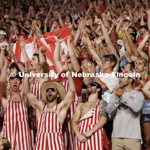 Fans in striped overalls cheer on the Husker football team. Northern Illinois football in Memorial Stadium. September 16, 2023. Photo by Craig Chandler / University Communication.