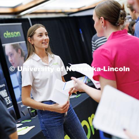 Recruiters including Tessa Yackley, a civil engineer with Olsson who stepped away from her engineering duties to help recruit, line up to talk with students about career opportunities. Career Fair in the Nebraska Union. September 20, 2023. Photo by Craig Chandler / University Communication.