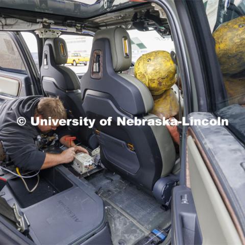 Trevor Donahoo, Engineering Testing Technician, connects testing equipment inside the Rivian R1T cab before the crash test. In research sponsored by the U.S. Army Engineer Research and Development Center, the University of Nebraska-Lincoln’s Midwest Roadside Safety Facility is investigating the safety and military defense questions raised by the burgeoning number of electric vehicles on the nation’s roadways. A crash test performed on a guardrail on October 12, 2023, highlighted the concern. At 60 mph, the 7,000-plus-pound, 2022 Rivian R1T truck tore through a commonly used guardrail system with little reduction in speed. October 12, 2023. Photo by Craig Chandler / University Communication and Marketing.
