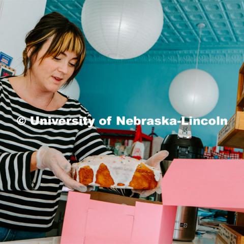 An employee boxes a cake at Goldenrod Bakery. About Lincoln at Goldenrod Bakery. October 17, 2023. Photo by Matthew Strasburger / University Communication.