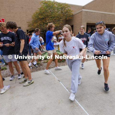 Outside of the Nebraska East Union, teams open their first clue envelope and run in multiple directions to begin the race. Each team is sent in a different order to each of 10 locations where they collect a clue to their next destination. Homecoming Traditions Race. Registered teams compete in a race to find 10 landmarks in an hour on UNL’s East Campus. October 24, 2023. Photo by Craig Chandler / University Communication.