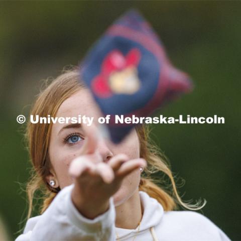 Sadie Larkins, who was competing for the Newman Center, lets a bag fly during Homecoming Cornhole Tournament in the greenspace by the Nebraska Union. October 25, 2023. Photo by Craig Chandler / University Communication.