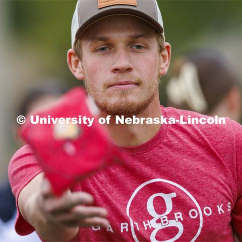 Bryce Wemhoff, who was competing for the Newman Center, lets a bag fly during Homecoming Cornhole Tournament in the greenspace by the Nebraska Union. October 25, 2023. Photo by Craig Chandler / University Communication.