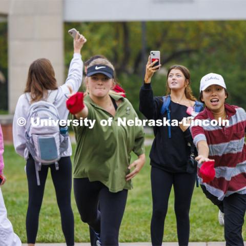 Nghi Ho, right, and Mackenzie Noble practice before the tournament begins as their friends record the action and themselves. The two were competing for Alpha Xi Delta. Cornhole Tournament in the greenspace by the Nebraska Union. October 25, 2023. Photo by Craig Chandler / University Communication.