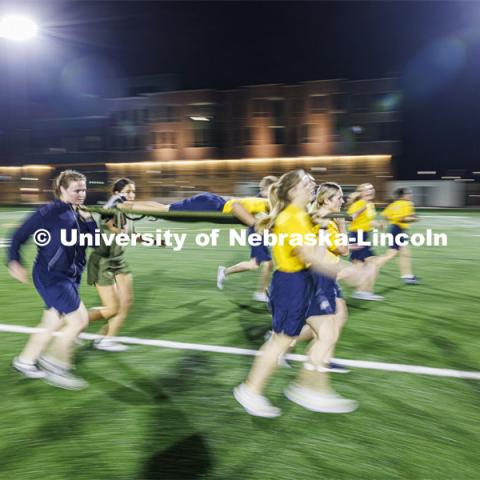 Female Navy midshipman race around Mabel Lee field during the during the casualty evacuation race. Each branch ran a timed 220 yard race for the male and female cadets and midshipman. ROTC Joint Field Meet is like an ROTC Olympics for the Nebraska cadets and midshipman. Army, Air Force and Navy/Marine cadets compete in events such as Maneuvering Under Fire, Log Sit-ups, Tug-Of-War, Casualty Evacuation and Ultimate Frisbee. Army beat Navy in a sudden death 4x400 relay to claim the title. October 26, 2023. Photo by Craig Chandler / University Communication.