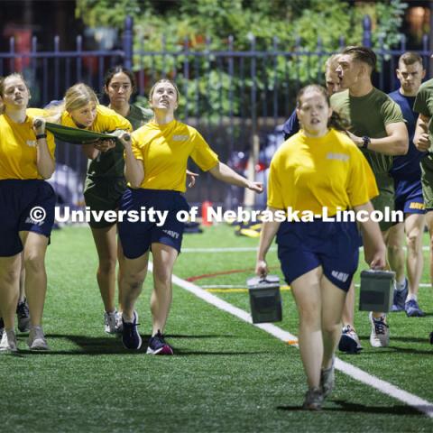 Female Navy midshipman are cheered on during the during the casualty evacuation race. Each branch ran a timed 220 yard race for the male and female cadets and midshipman. ROTC Joint Field Meet is like an ROTC Olympics for the Nebraska cadets and midshipman. Army, Air Force and Navy/Marine cadets and midshipmen compete in events such as Maneuvering Under Fire, Log Sit-ups, Tug-Of-War, Casualty Evacuation and Ultimate Frisbee. Army beat Navy in a sudden death 4x400 relay to claim the title. October 26, 2023. Photo by Craig Chandler / University Communication.