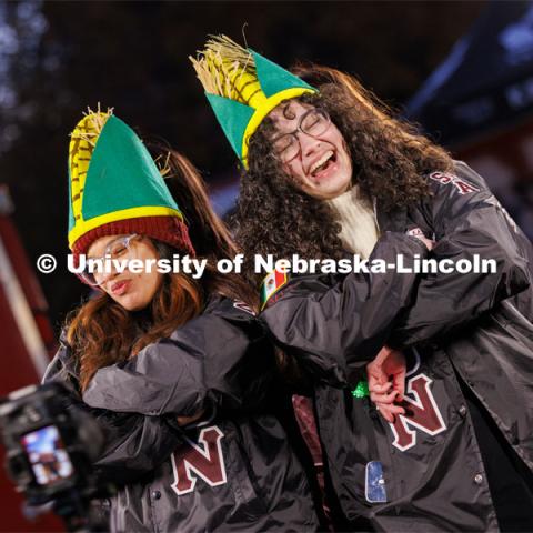 Monica Samaniego, left, and Solenne Halman Gonzalez wear corn hats and their Lambda Theta Nu sorority jackets as they pose in a 360 degree photo booth. Homecoming parade and Cornstock. October 27, 2023. Photo by Craig Chandler / University Communication.
