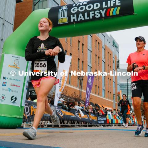 Runners cross the finish line. The Good Life Halfsy half marathon runs through the streets of Lincoln and end downtown in the Haymarket. About Lincoln at the Good Life Halfsy. November 5, 2023. Photo by Matthew Strasburger / University Communication.