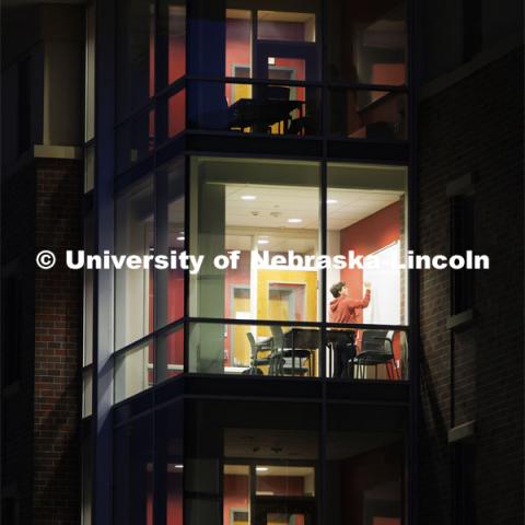 A student works on problems in a University Suites study room Thursday evening. City Campus. December 7, 2023. Photo by Craig Chandler / University Communication and Marketing.