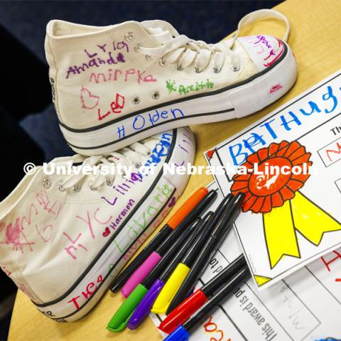 Crandall Blake’s signed and decorated high tops sit on a table next to awards done for her by each student in her kindergarten class at Lakeview Elementary. The award at right is for Blake being the best hugger. She had her students sign a pair of white high-top shoes which she will wear at commencement so “her entire class can walk across stage with her”. December 13, 2023. Photo by Craig Chandler / University Communication and Marketing.