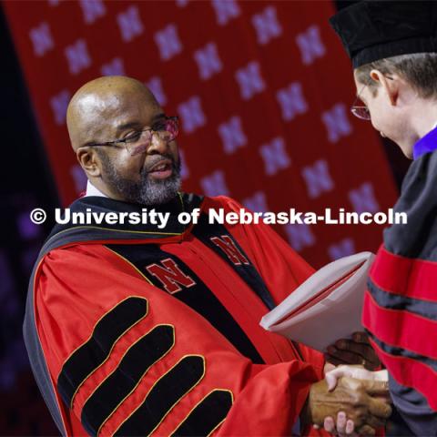 Chancellor Rodney D. Bennett awards a diploma to a PhD graduate. Graduate Commencement at Pinnacle Bank Arena. December 15, 2023. Photo by Craig Chandler / University Communication and Marketing.