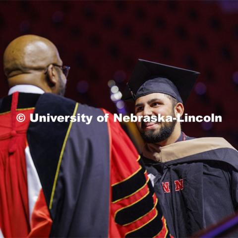 Alex Fernando shakes hands with Chancellor Rodney Bennett after being given his MBA diploma. Graduate Commencement at Pinnacle Bank Arena. December 15, 2023. Photo by Craig Chandler / University Communication and Marketing.