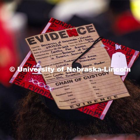 Caitlin Garcia wears the evidence of her college experience on her mortar board. Winter undergraduate commencement in Pinnacle Bank Arena. December 16, 2023. Photo by Craig Chandler / University Communication and Marketing.