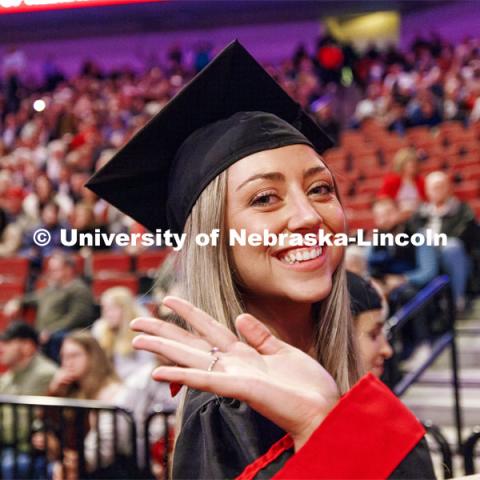 Chloe Schock, CoJMC graduate, waves as she leaves the arena. Winter undergraduate commencement in Pinnacle Bank Arena. December 16, 2023. Photo by Craig Chandler / University Communication and Marketing.