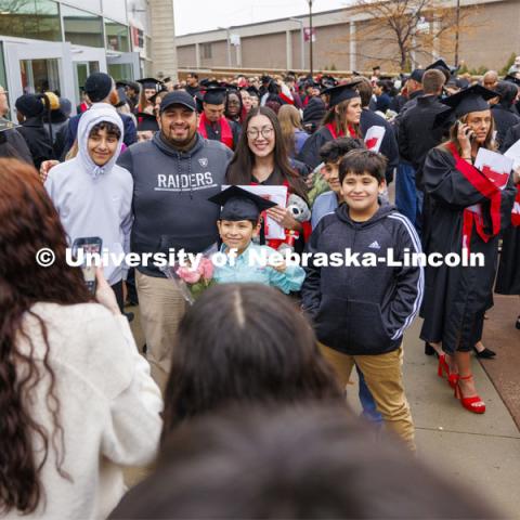 CEHS graduate Ruby Garcia Gonzalez is surrounded by family and friends for photos outside the arena after commencement. Winter undergraduate commencement in Pinnacle Bank Arena. December 16, 2023. Photo by Craig Chandler / University Communication and Marketing.