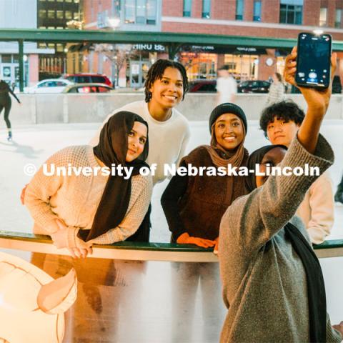 Students stop for a selfie at the Railyard Rink. Ice skating in the Haymarket. Photos for About Lincoln website. For About Lincoln website. December 12, 2023. Photo by Matthew Strasburger / University Communication.