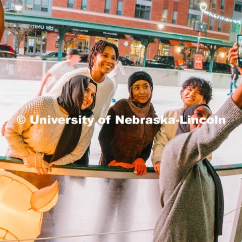 Students stop for a selfie at the Railyard Rink. Ice skating in the Haymarket. Photos for About Lincoln website. For About Lincoln website. December 12, 2023. Photo by Matthew Strasburger / University Communication.