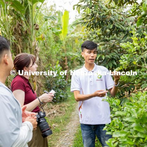 Milana Doné takes notes while interviewing Le Phuc, 22, a production manager at Abavina, an organic farming operation in Can Tho, Vietnam. Abavina was the main story that Doné was following to see how they operate and how they teach other farmers in Vietnam this way of farming to deter the use of chemicals and pesticides. In the foreground is Dang Huynh, a 34-year-old from Ho Chi Minh City, he works for the Vietnam office of the Global Engagement Institute (GEI) which was the in-country partner. He was working as translator for the interview. Global Eyewitness. January 14, 2024. Photo by Kirk Rangel